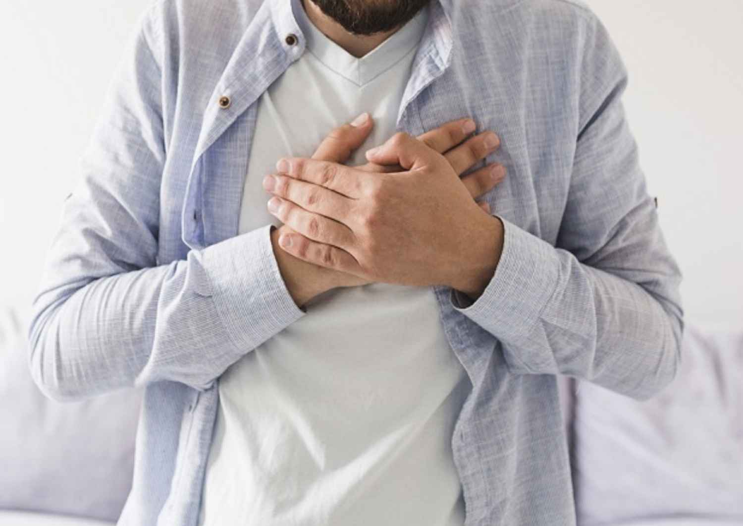 Mains serrant sa poitrine pour illustrer la douleur physique liée au deuil somatique